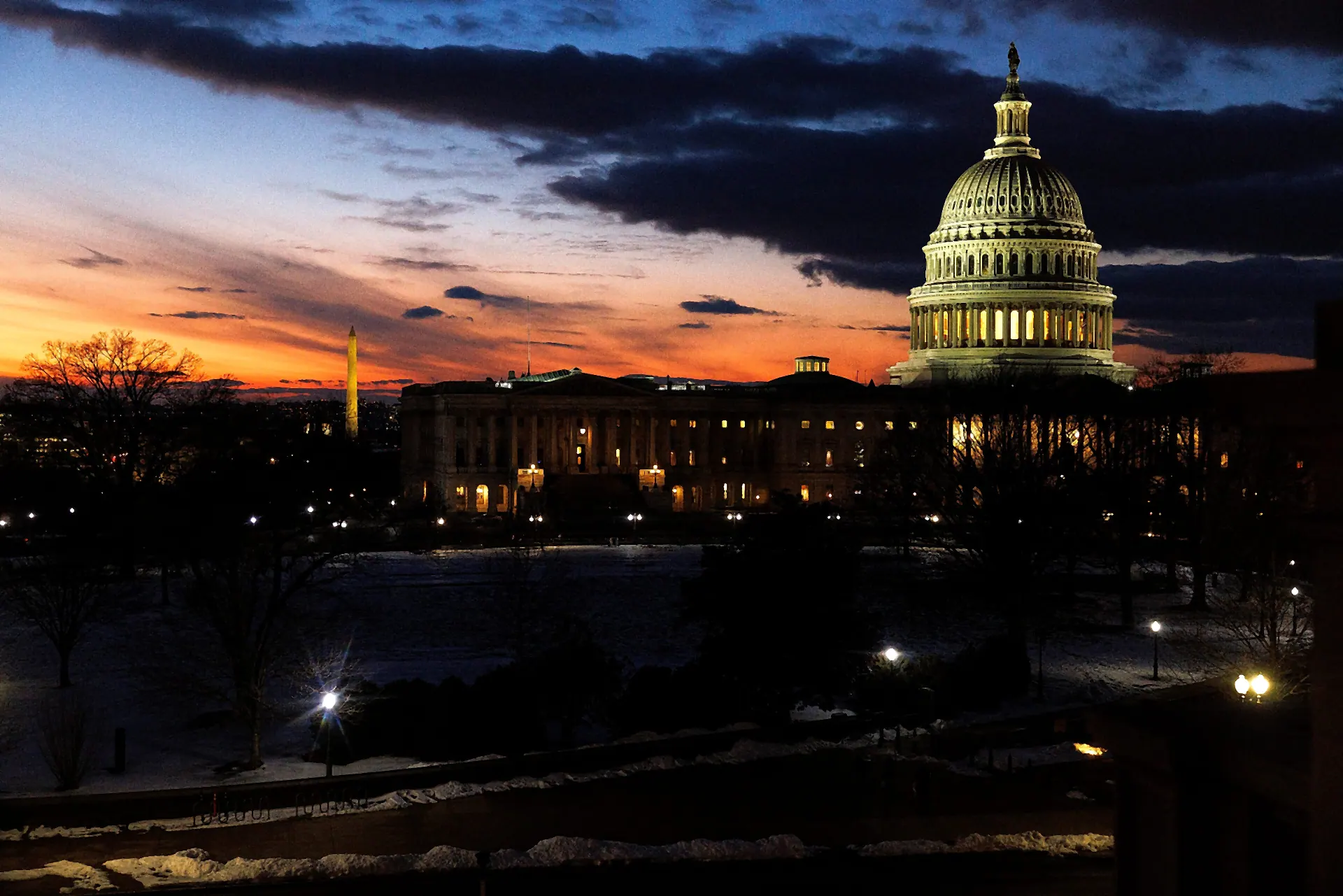 The United States Capitol at sunset, seen from the Library of Congress, with the Washington Monument on the horizon.